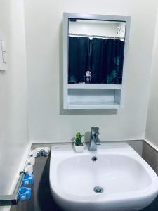 lavabo blanco en un baño con ventana en Persimmon Studios Condominium Cebu City, en Cebú