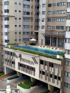 un hotel con piscina frente a un edificio en Persimmon Studios Condominium Cebu City, en Cebú