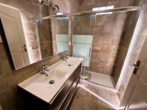 a bathroom with a sink and a mirror and a shower at Villa Preciosa in Les tres Cales +6 photos