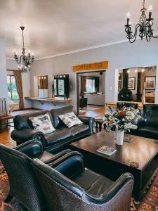 Assegaaibosch Country Lodge في Kareedouw: غرفة معيشة بأثاث جلدي وطاولة
