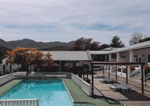 a pool at a hotel with mountains in the background at Assegaaibosch Country Lodge in Kareedouw