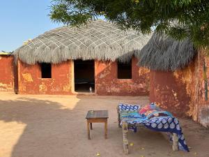 dom z krzesłem i stołem przed nim w obiekcie Jaisalmer Safari Base & Camp w mieście Khuri