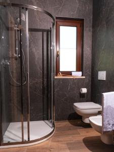 uma casa de banho com um chuveiro e um WC. em Appartamento Talamone - Santa Francesca em Talamone