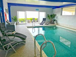 ein großer Swimmingpool mit Liegen und einer Liege und einem Stuhl istg in der Unterkunft Thanckes House in Torpoint