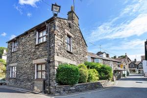a stone building with a clock on the top of it at Finest Retreats - Otters Holt in Ambleside