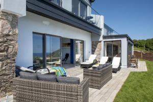 eine Terrasse mit Sofas und Stühlen auf einem Haus in der Unterkunft Thanckes House in Torpoint