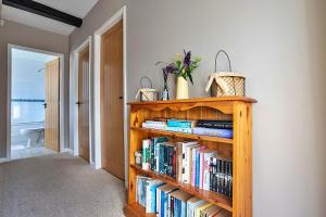 a book shelf filled with books in a hallway at Finest Retreats - Otters Holt in Ambleside