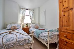 a bedroom with two beds and a window at Finest Retreats - Otters Holt in Ambleside
