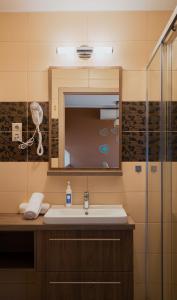La salle de bains est pourvue d'un lavabo et d'un miroir. dans l'établissement Zafír Apartmanház, à Sárvár