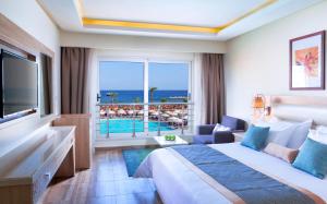 Beach Albatros Aqua Park - Hurghada في الغردقة: غرفة فندقية بسرير وإطلالة على المحيط