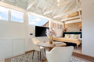 a room with a bed and a table and chairs at Genteel Home Catedral Granada in Granada +46 photos
