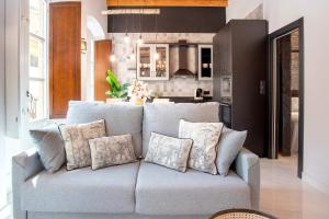 a living room with a couch and a kitchen at Genteel Home Catedral Granada in Granada