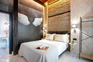 a bedroom with a bed and a brick wall at Genteel Home Catedral Granada in Granada