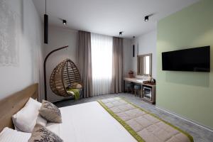 um quarto de hotel com uma cama e uma televisão de ecrã plano em EcoDor em Orhei