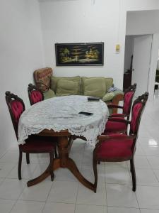 De' Aman Homestay في جيترا: طاولة مع كراسي وأريكة في الغرفة