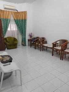 sala de estar con sillas, mesas y sofá en De' Aman Homestay, en Jitra