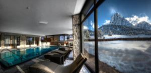 a house with a swimming pool with a mountain view at Monte Pana Dolomites Hotel in Santa Cristina Gherdëina