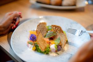 圣克里斯蒂娜Monte Pana Dolomites Hotel的木桌上的白盘食物