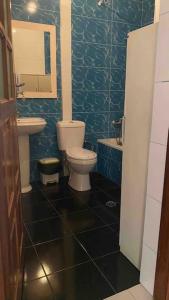 La salle de bains bleue est pourvue de toilettes et d'un lavabo. dans l'établissement Maison familiale à Tarrafal., à Tarrafal