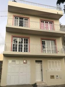 a large house with a balcony and two doors at Maison familiale à Tarrafal. in Tarrafal