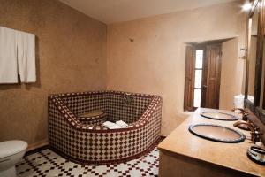 a bathroom with a wicker basket in the corner at Riad Dar Laura in Fès