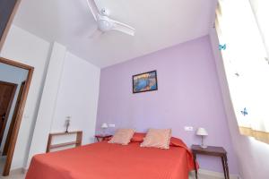 Schlafzimmer mit einem roten Bett und einem Deckenventilator in der Unterkunft Casa Coro by SIERRA VIVA in Cortelazor