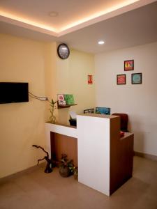 an office with a desk and a clock on the wall at Libra Cottage in Port Blair