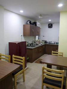 a kitchen with wooden cabinets and wooden tables and chairs at Libra Cottage in Port Blair