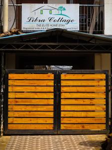 a wooden gate in front of a building at Libra Cottage in Port Blair