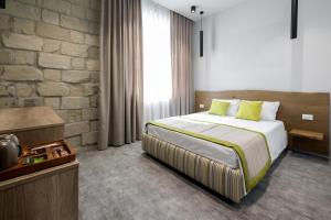 um quarto com uma cama e uma parede de tijolos em EcoDor em Orhei