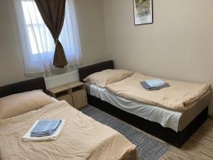 two beds in a room with towels on them at Aba-Böbe Vendégház Zalaszentiván in Zalaszentiván