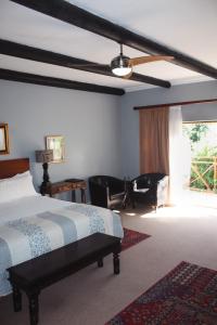 1 dormitorio con 1 cama y ventilador de techo en Assegaaibosch Country Lodge en Kareedouw