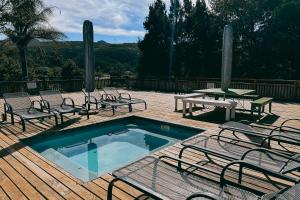 una terraza con piscina, sillas y mesa de picnic en Assegaaibosch Country Lodge en Kareedouw