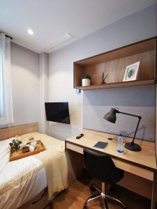 a bedroom with a bed and a desk with a lamp at NODIS MADRID POZUELO in Madrid