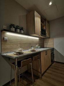 a kitchen with a counter with chairs and a table at NODIS MADRID POZUELO in Madrid
