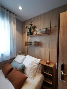 a bedroom with a bed and a wooden wall at NODIS MADRID POZUELO in Madrid