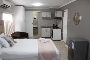 Un dormitorio con una cama grande y una cocina. en 103onWallace Self Catering Guest House, en Ciudad del Cabo