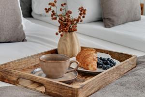 een dienblad met een koffiekopje en een bord croissants en bosbessen bij Angielska Grobla - City Center, Marina & Parking by Downtown Apartments in Gdańsk