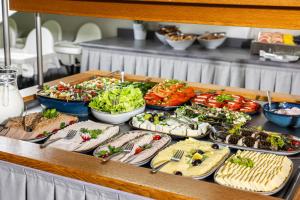 - un buffet avec de nombreuses assiettes de nourriture sur une table dans l'établissement Maloves Resort & Spa, à Władysławowo