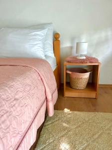 um quarto com uma cama e uma mesa com um candeeiro em Guesthouse D&D em Ličko Petrovo Selo