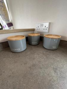 three trash cans sitting on the floor in a room at Luxurious Three Bedroom Caravan in Jaywick Sands
