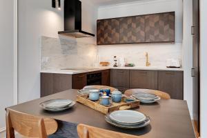 uma cozinha com uma mesa com pratos e tigelas em Downtown Apartments Angielska Grobla - City Center & Parking em Gdansk