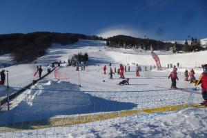 a group of people skiing down a snow covered slope at Centre station Super Besse Studio in Besse-et-Saint-Anastaise