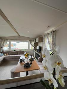 a living room with a table and a couch at Luxurious Three Bedroom Caravan in Jaywick Sands