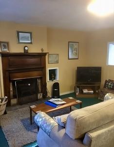 a living room with a couch and a fireplace at Pond Cottage in Covington
