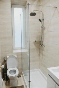 a bathroom with a toilet and a glass shower at Embassy Arriaga Private Elegance Rooms in Stylish Shared Apartment in Lisbon