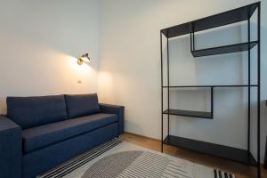 2-rooms apartment 10 min away from city center في فيينا: غرفة معيشة مع أريكة وخزانة كتاب زجاجية