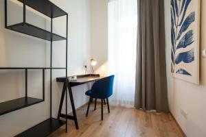 Habitación con escritorio y silla azul. en 2-rooms apartment 10 min away from city center, en Viena