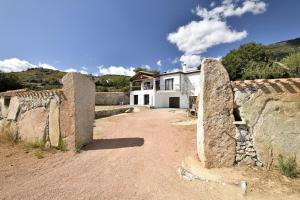 una casa con una pared de piedra junto a un camino de tierra en Casa Ami, en Arzana