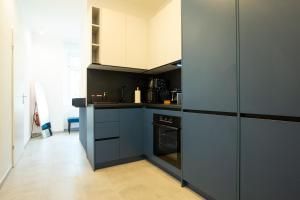 2-rooms apartment 10 min away from city center في فيينا: مطبخ مع دواليب زرقاء وموقد